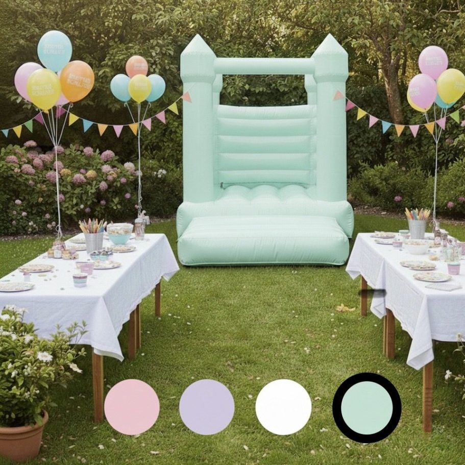 Grüne Hüpfburg mit Rutschen und Zeltspitzen, umgeben von Blumen und Bäumen.